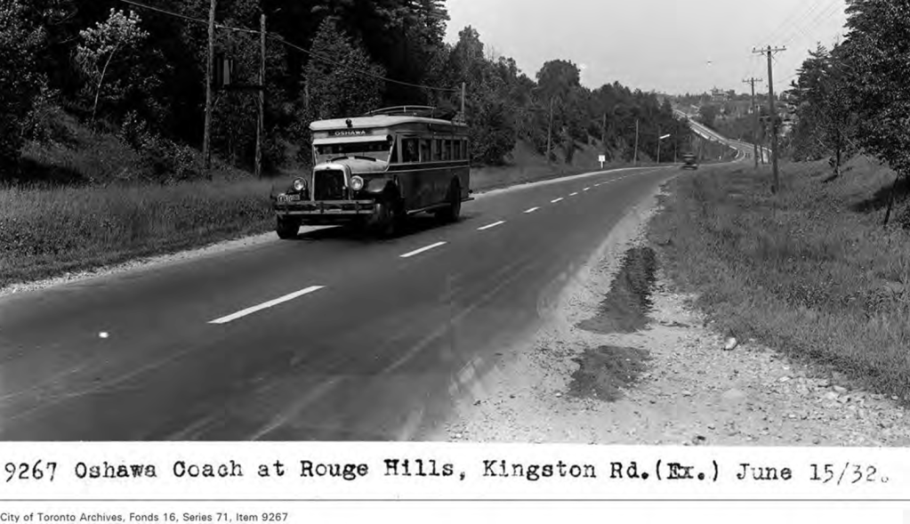 Black and white image of an early bus on a road